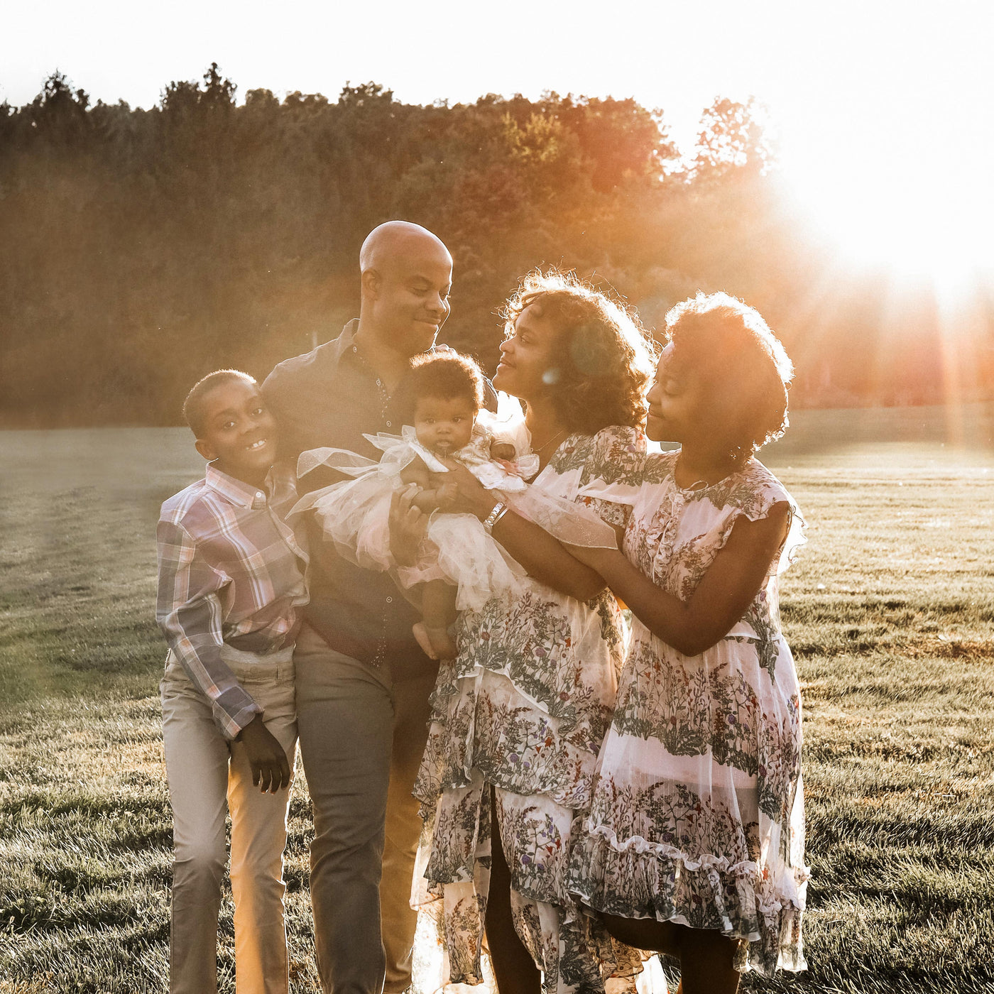 The Johnsons family standing in a field with the sun behind them